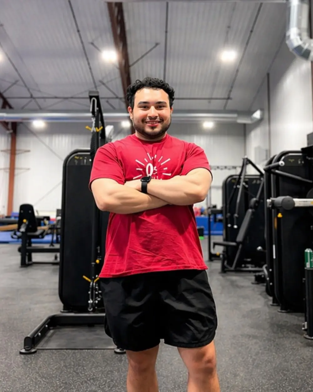 A ONE Athletics trainer standing in the Fitness Zone weight room