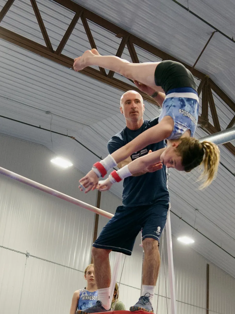 Owner and head coach Valentin Frunzac spotting a gymnast on the high bar