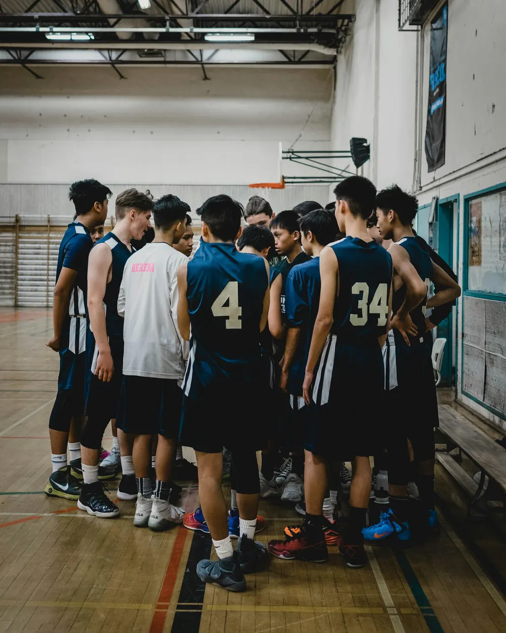 A youth basketball team huddled together on the court